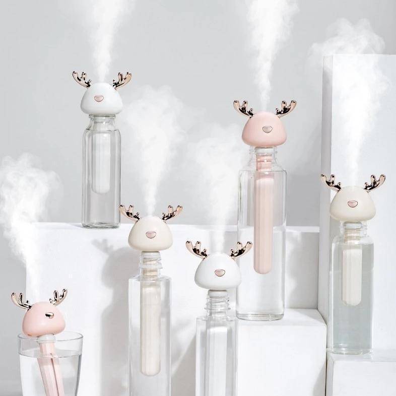 White and Pink Colored Portable Humidifiers with deer antlers in clear bottles of water - white background