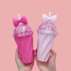 Two hands holding Pink & hot pink Belle bow cup - home & office - peach background