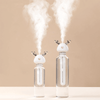 Load image into Gallery viewer, Short &amp; tall Ava portable humidifiers in glass bottles on white table - mauve background - mist in air