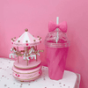 Hot pink Belle bow cup next to pink toy carousel - hot pink background - home & office
