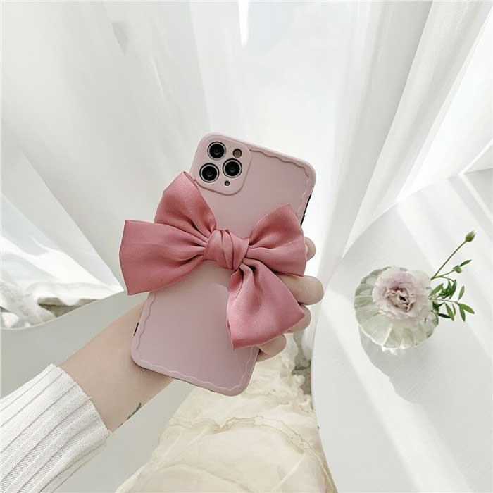 Matte Minimalist Paris Pink Belle Bow Case showing back of phone and linen bow, with crystal flower vase on white table in background