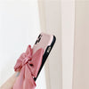 Side view of Matte Minimalist Paris Pink Belle Bow Case showing back of phone and linen bow, and black trim of a sleek iPhone