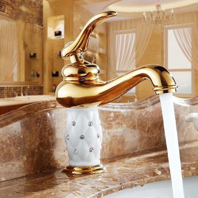 Coco glam faucet - 1 / short - opulence and gold glam galore. The gold faucet accented by white ceramic core  set on brown marble sink looks warm and tastefully decorated. Windows, chandelier, even shelving all reflect shades of gold for an indulgent yet classy statement 