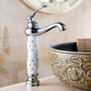 Coco glam faucet - 3 / tall - home & office. Silver faucet supported by white bejewelled ceramic core over elaborate elevated sink against tiled wall