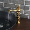 Coco glam faucet - 6 / tall - home & office. Exotic look of the gold on gold tall faucet open over a black elevated sink on dark polished wood surface. Water bubbles and in sink as aerator reduces splash and controls flow.