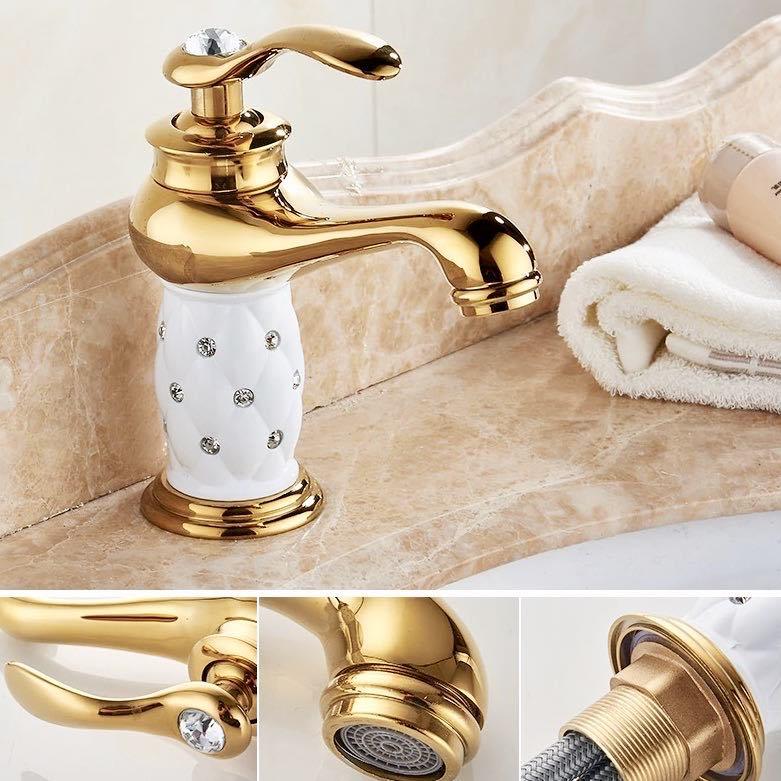 Coco glam faucet - brass fixture beauty. Main picture shows polished faucet with white ceramic core on beige marble counter with folded white towel and lotion in the corner. 3 smaller images underneath show the mixer lever with large crystal embedded in handle, under side of spout with bubbler/aerator attached, and connector tubes securely attached to base of the Coco Glam Faucet