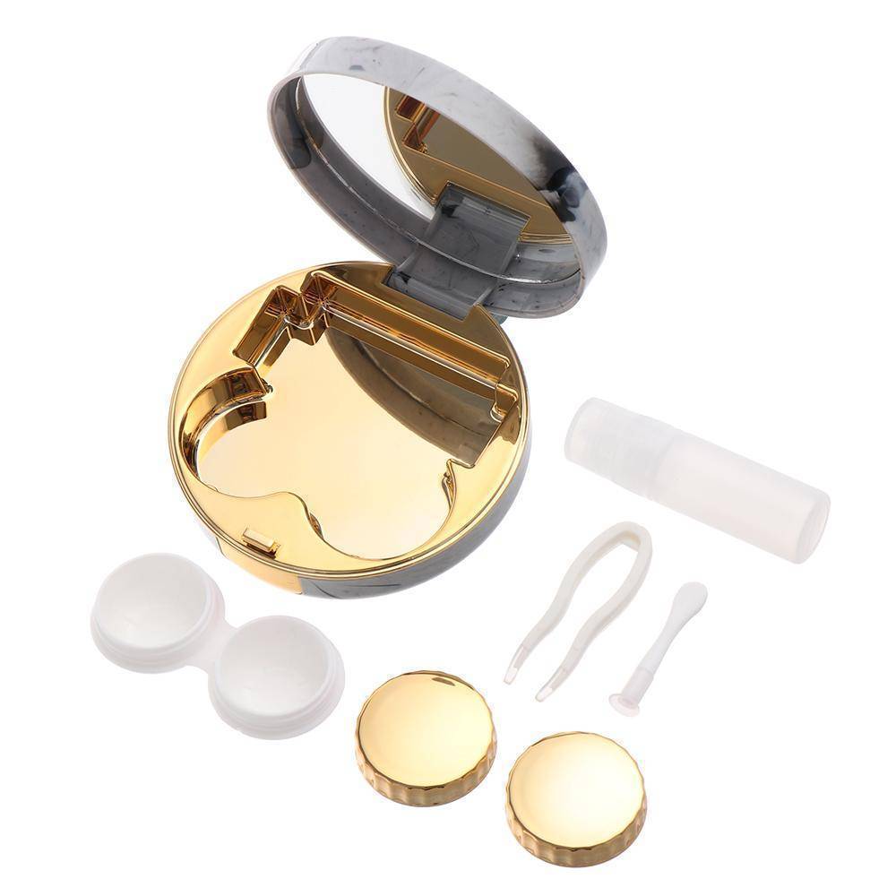 Unity contacts kit - gold - accessories. Unity contacts kit - accessories. Open gold kit displaying inner lid mirror, solution bottle, lens holder, lens holder covers & tweezers. Designated slots for each item inlaid in the gold interior. 